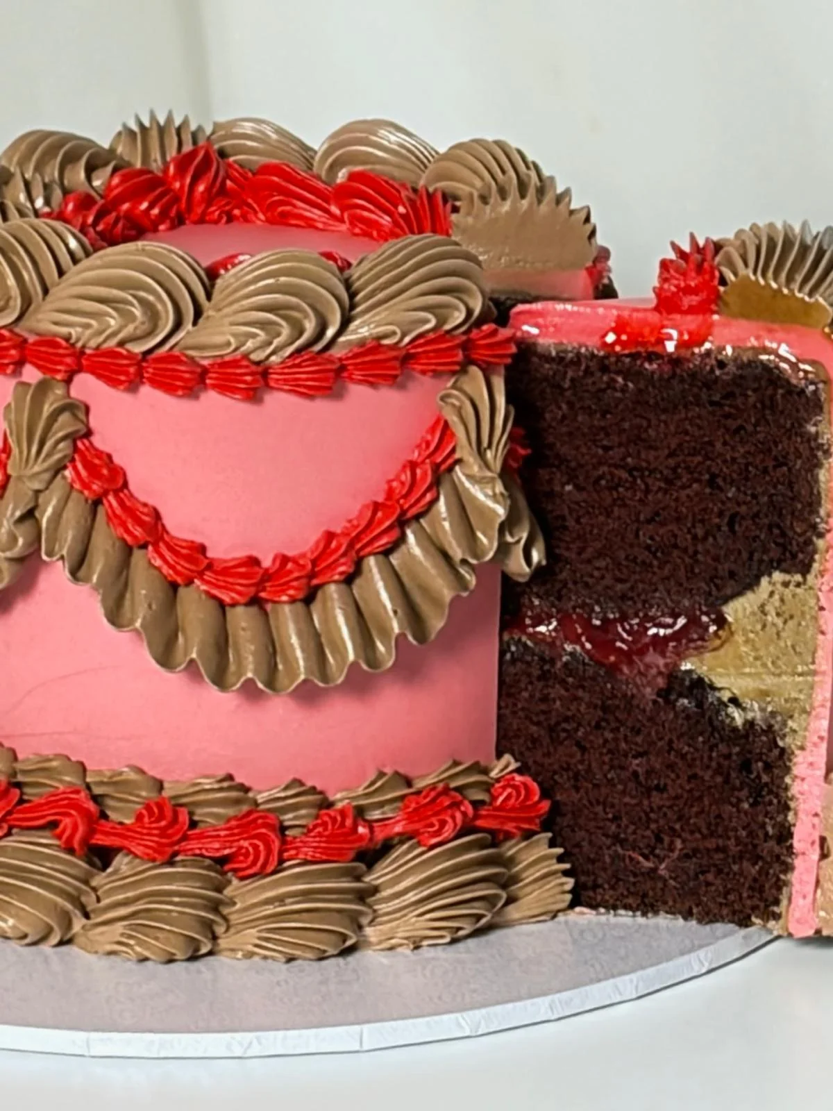 Pink heart cake sliced open to reveal chocolate sponge layers