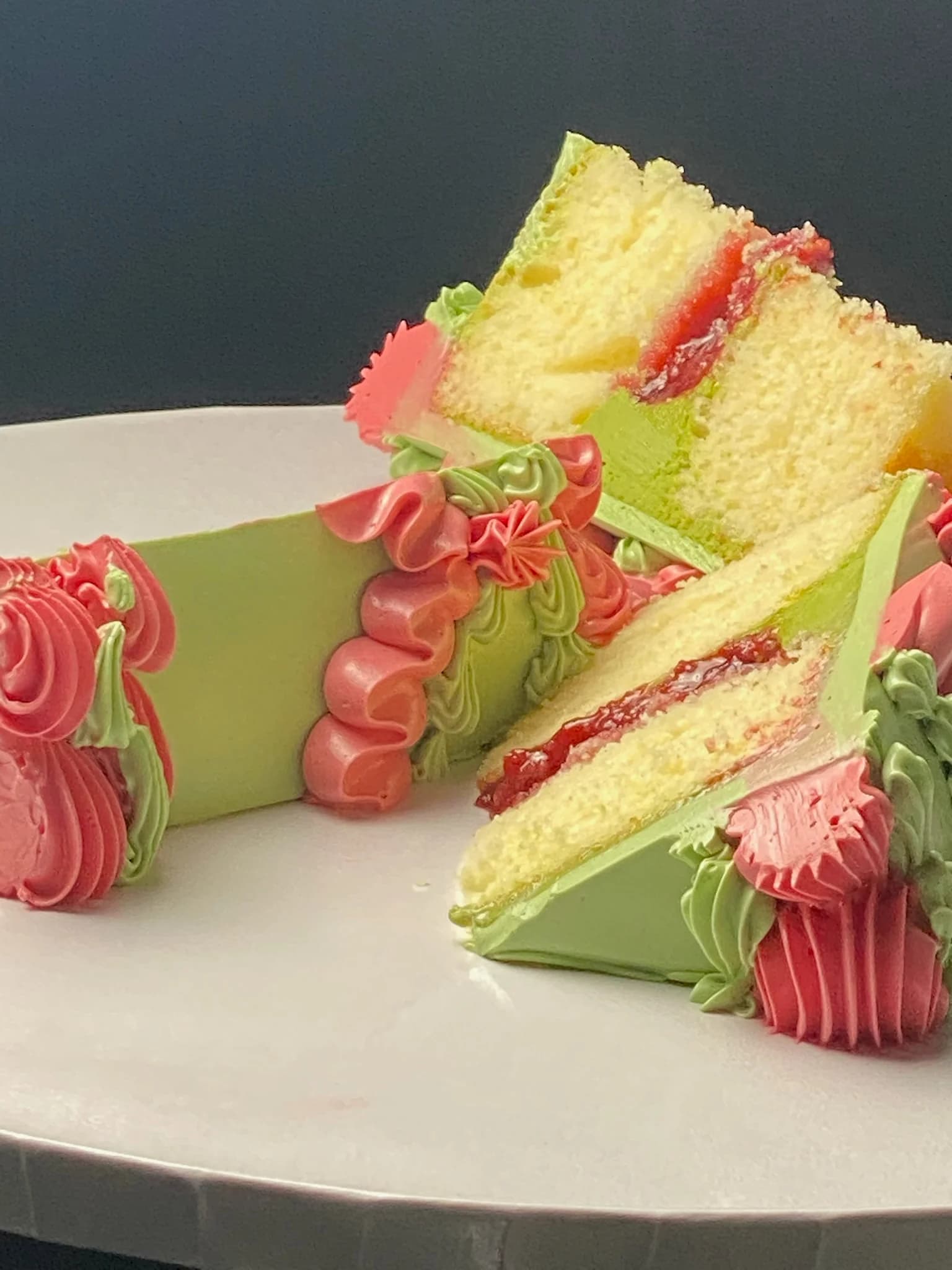 Green celebration cake cut open to show the sponge inside