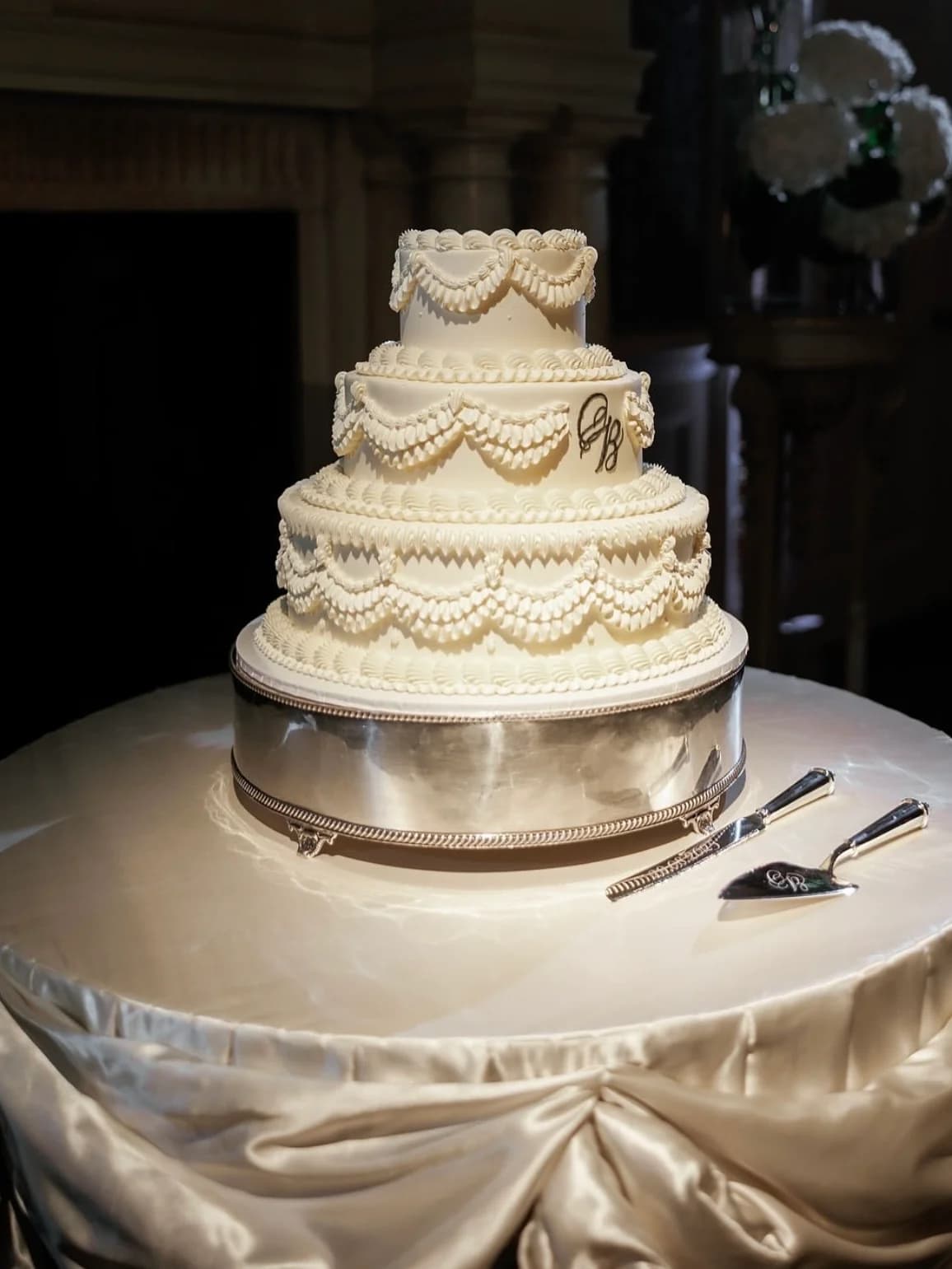 Three-tier white wedding cake with piped details