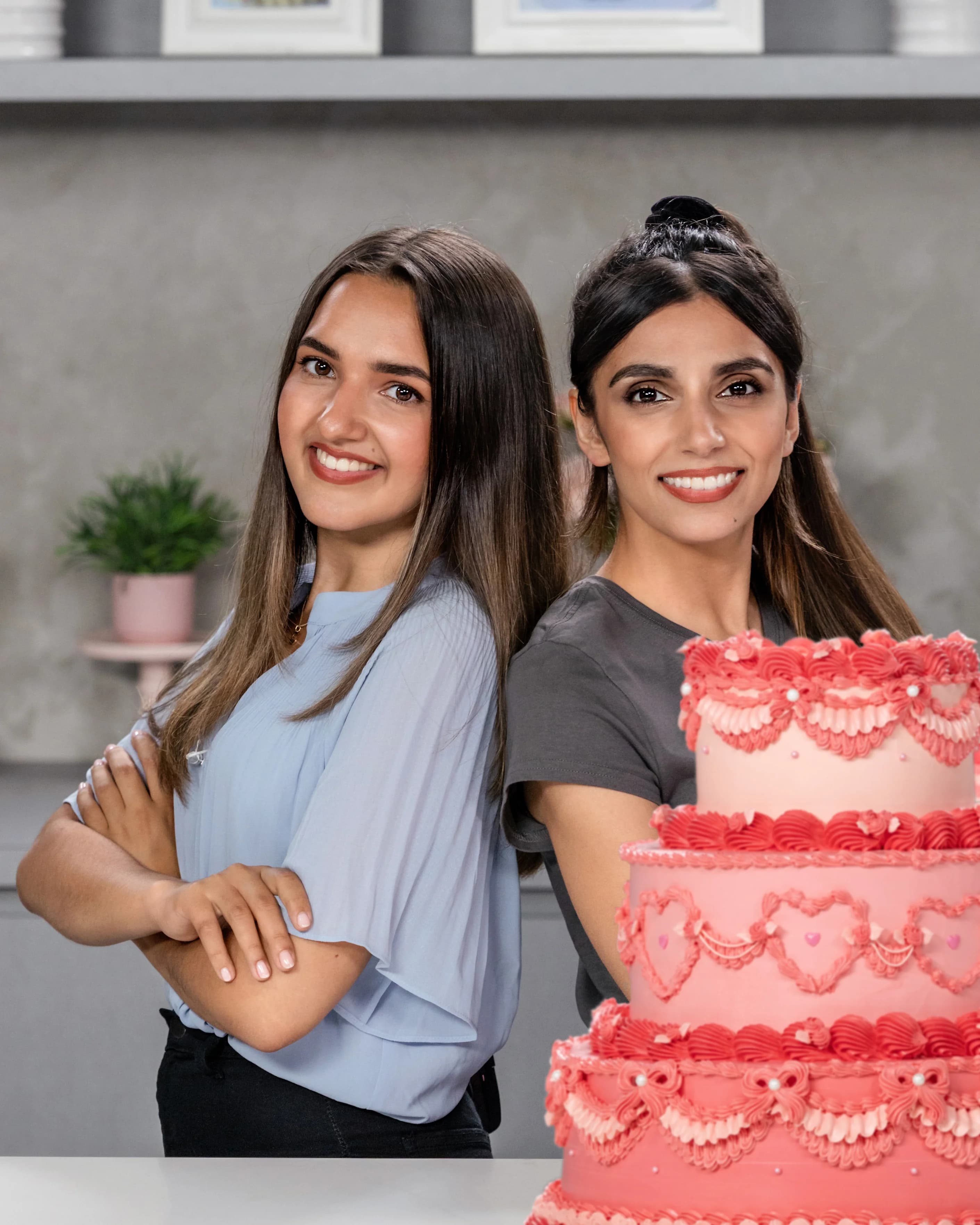 Two smiling students showing off their decorated cakes